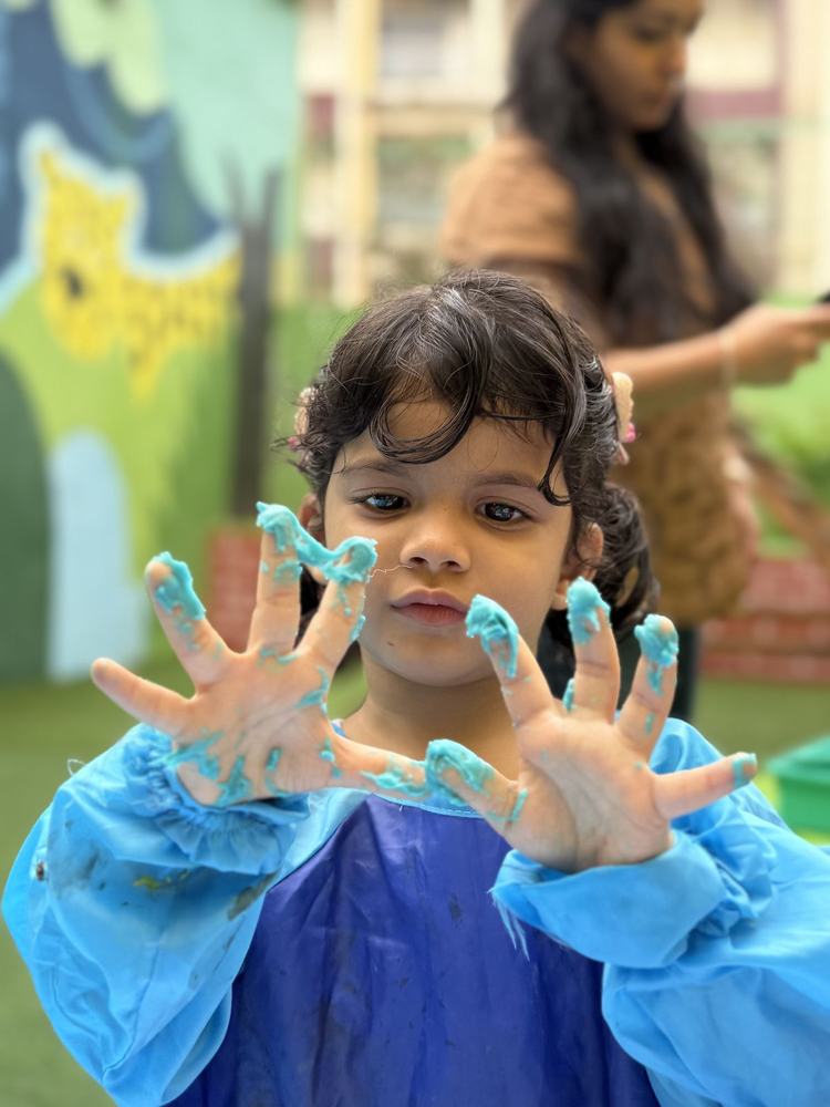 A child showing hands covered in blue paint